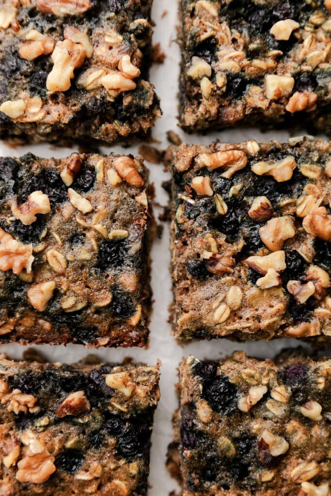 Close up overhead view oatmeal breakfast bars with wild blueberries and walnuts cut into squares