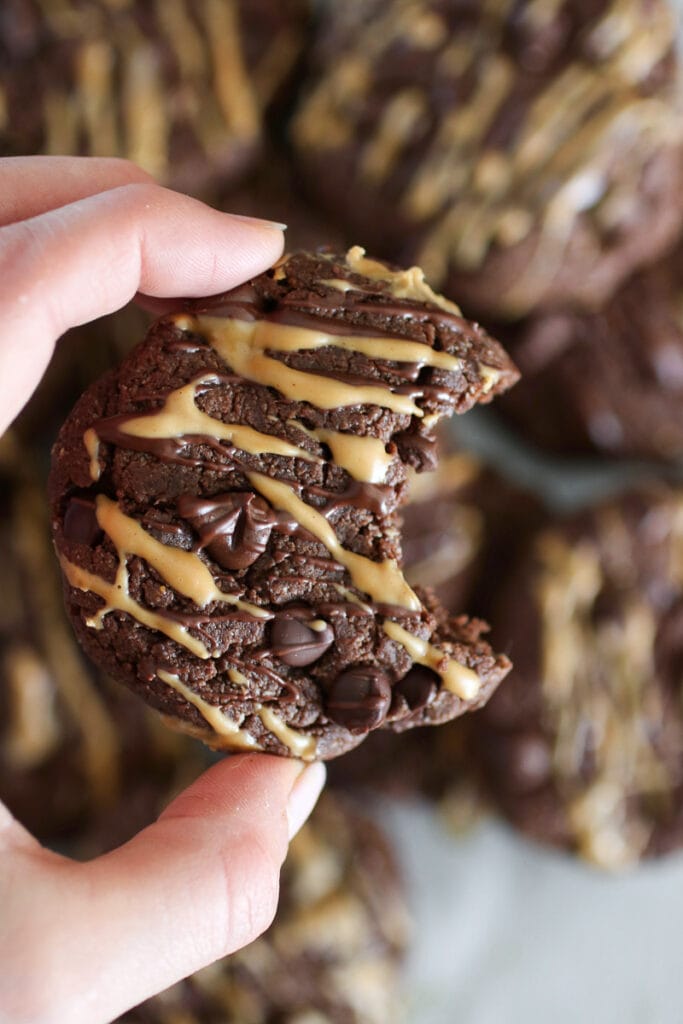 A chocolate protein cookie with a bite taken out of it. 