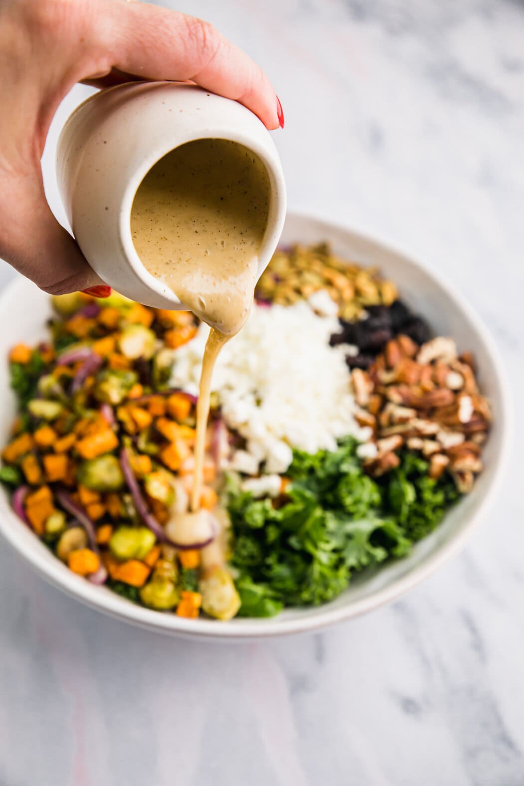 Dressing being poured onto a lentil salad in serving bowl