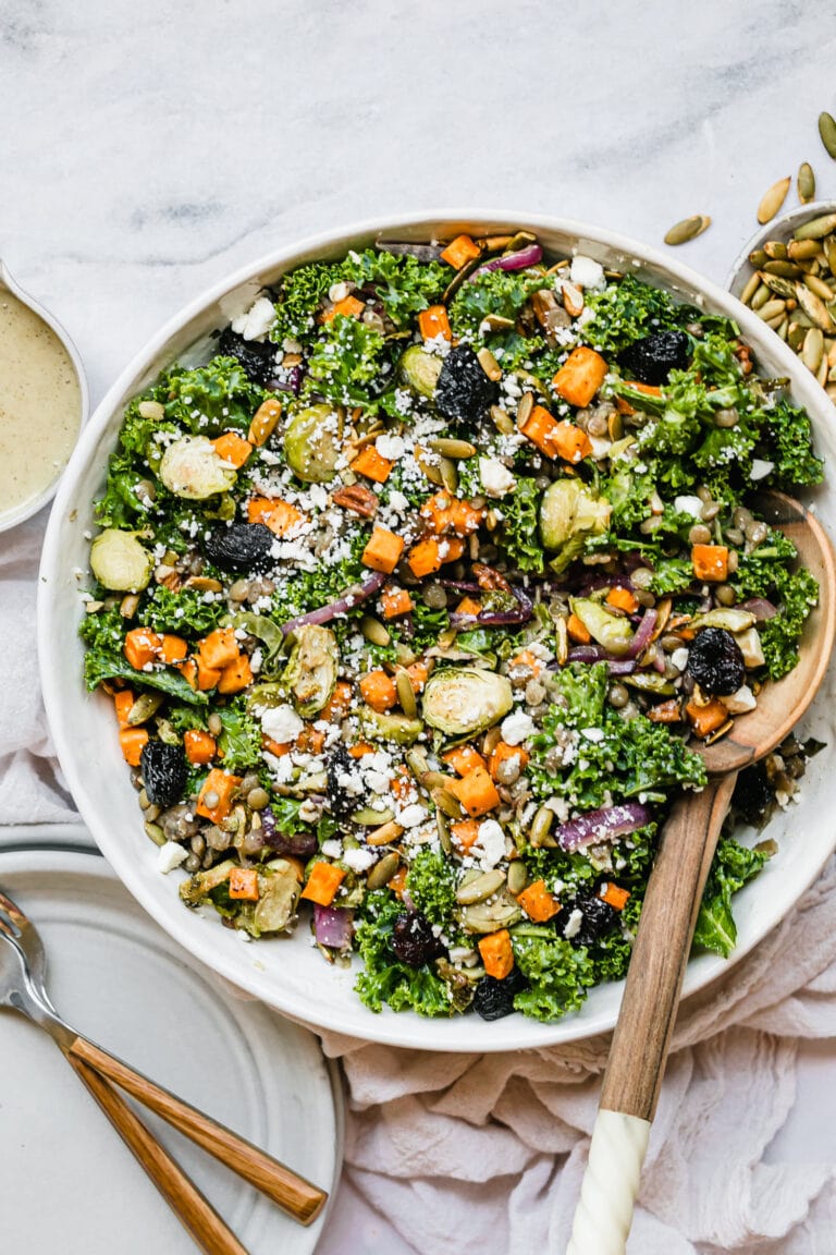 Overhead view of a white bowl of lentil salad with roasted vegetables tossed in a maple-Dijon-olive oil vinaigrette. 