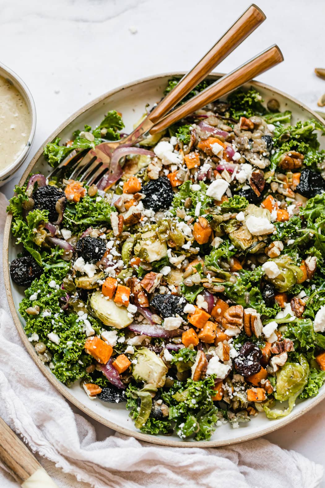 Lentil salad tossed with dressing, roasted vegetables and topped with feta cheese served in stone serving bowl