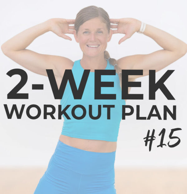 Woman in blue workout top and legging holding her hands behind her head.