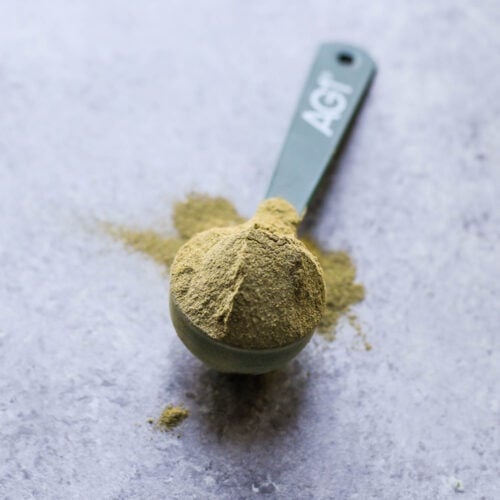 AG1 (Athletic Greens) powder in scoop on countertop