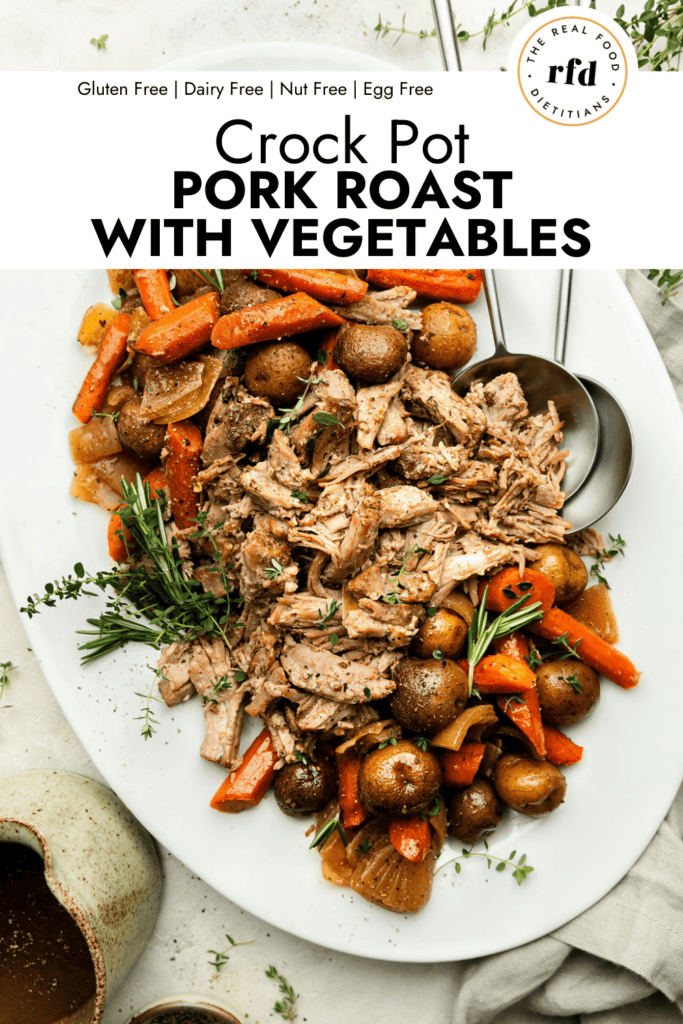 White platter filled with shredded crockpot pork roast with potatoes and carrots