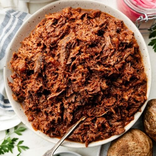 Overhead view shredded BBQ beef served in white serving bowl
