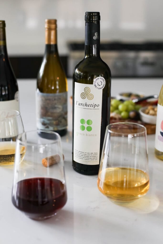 Bottles of wine with Dry Farm Wines label on countertop with charcuterie board in background