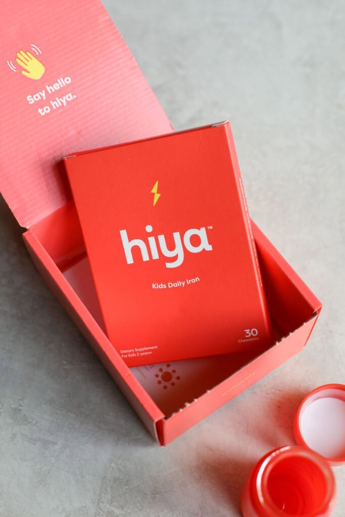 Red box packaging for Hiya kids daily iron plus supplement on countertop.