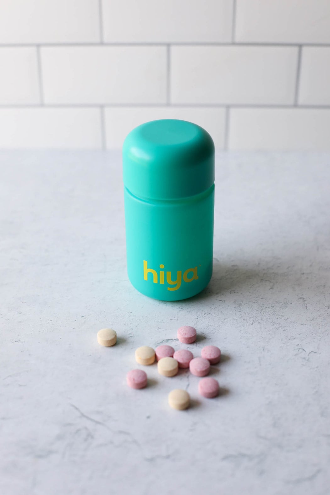 Hiya kids probiotic bottle standing upright on countertop with a few chewable tables on counter in front of bottle