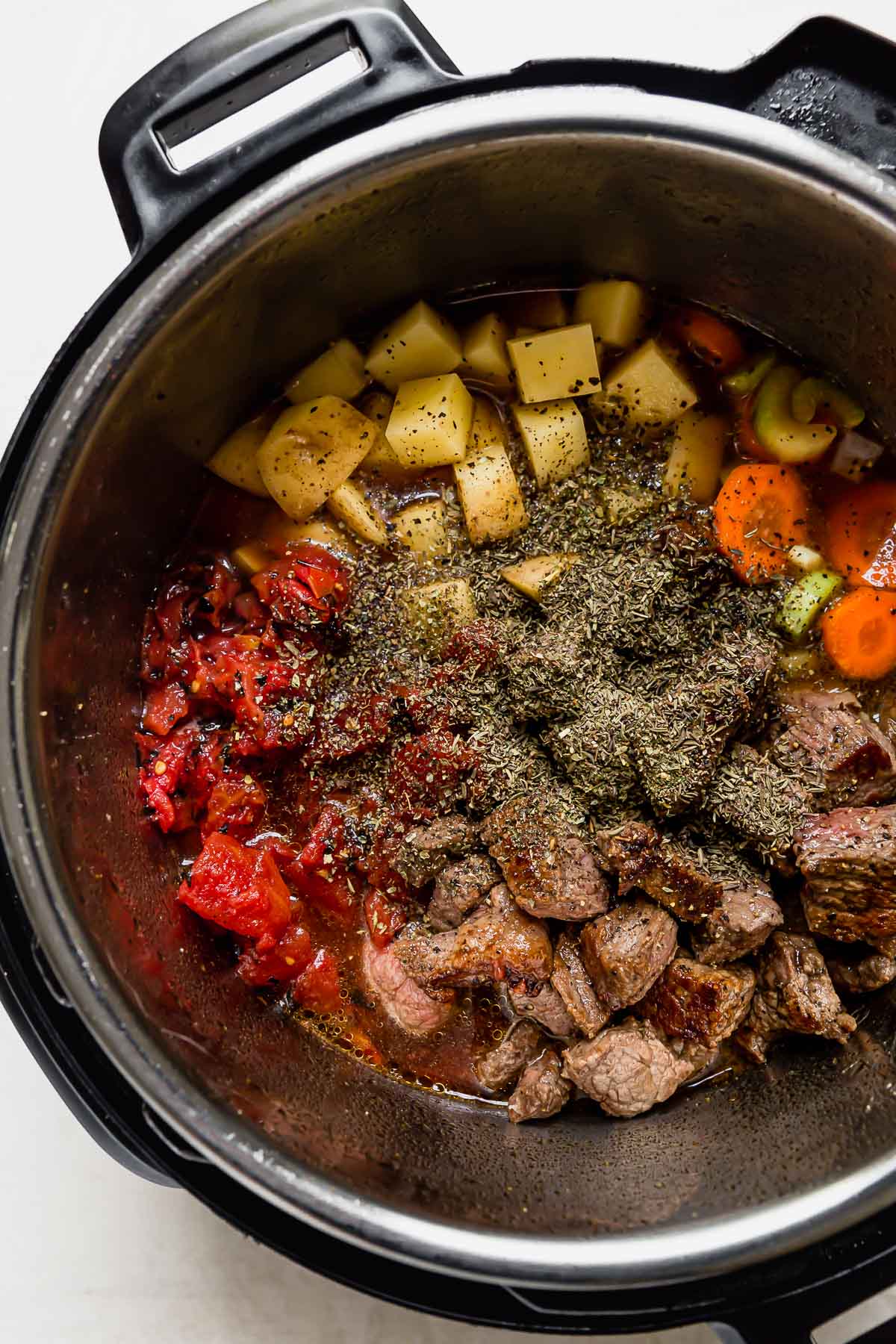 All ingredients for vegetable beef soup in an instant pot ready to be cooked