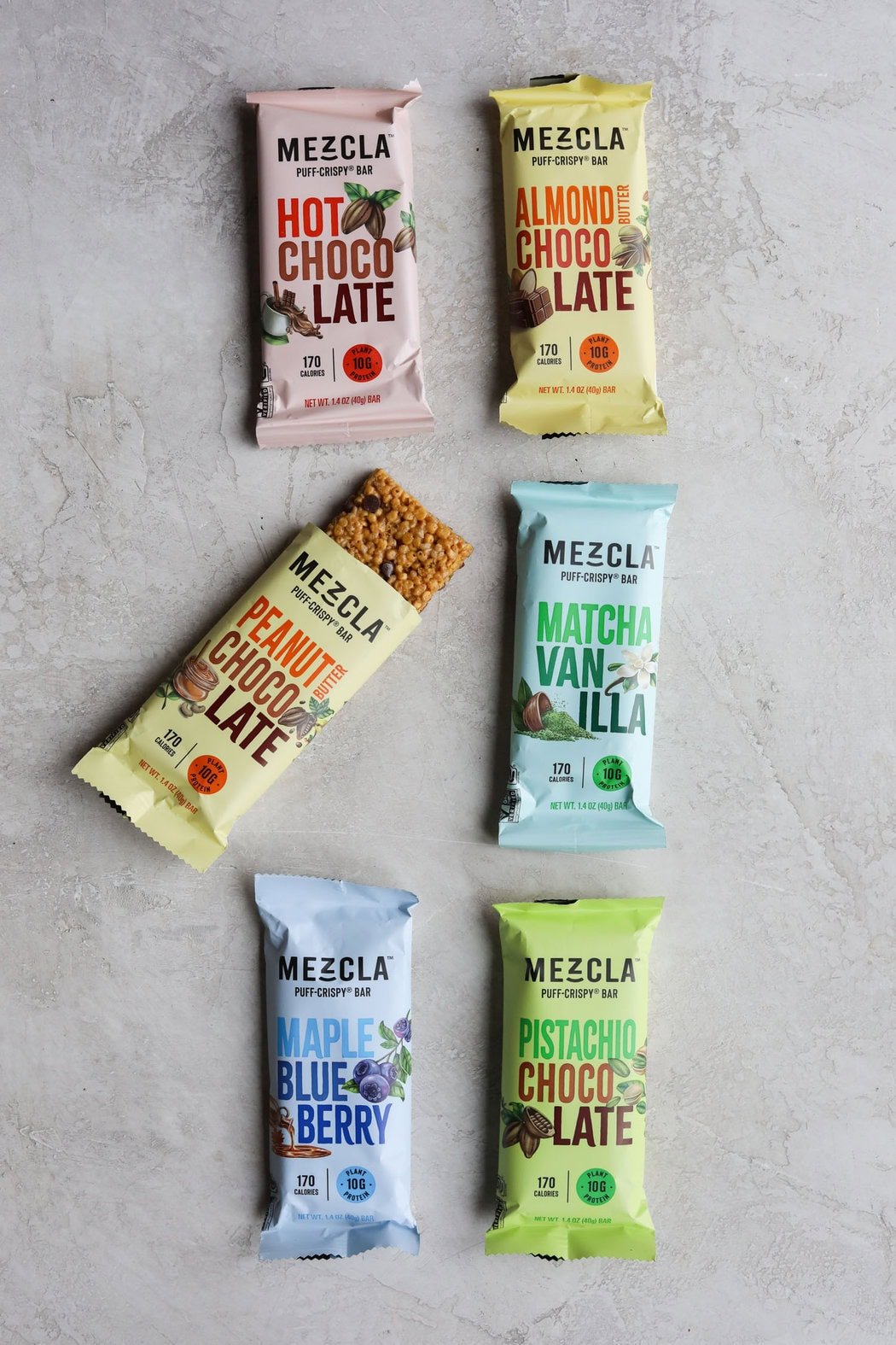 Overhead view of Mezcla protein bars with one opened to show texture. 