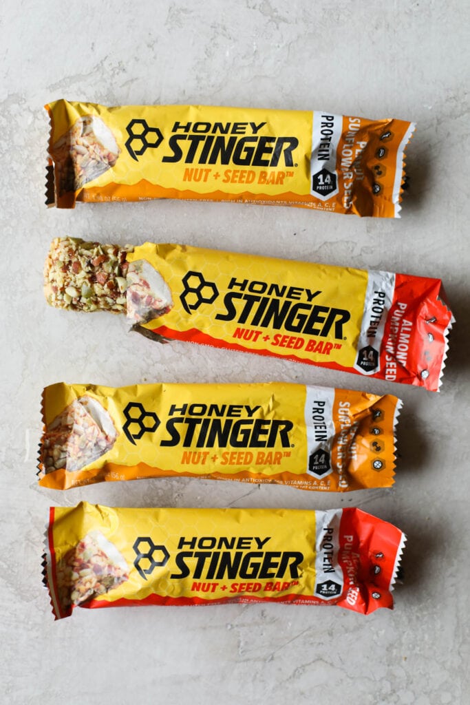 Overhead view Honey Stinger protein bars on countertop with one package open to show protein bar