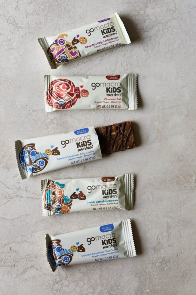 Overhead view GoMacro kids protein bars on countertop with one package open to show protein bar