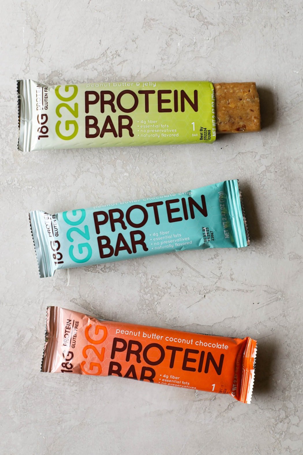 Overhead view G2G protein bars on countertop with one package open to show protein bar