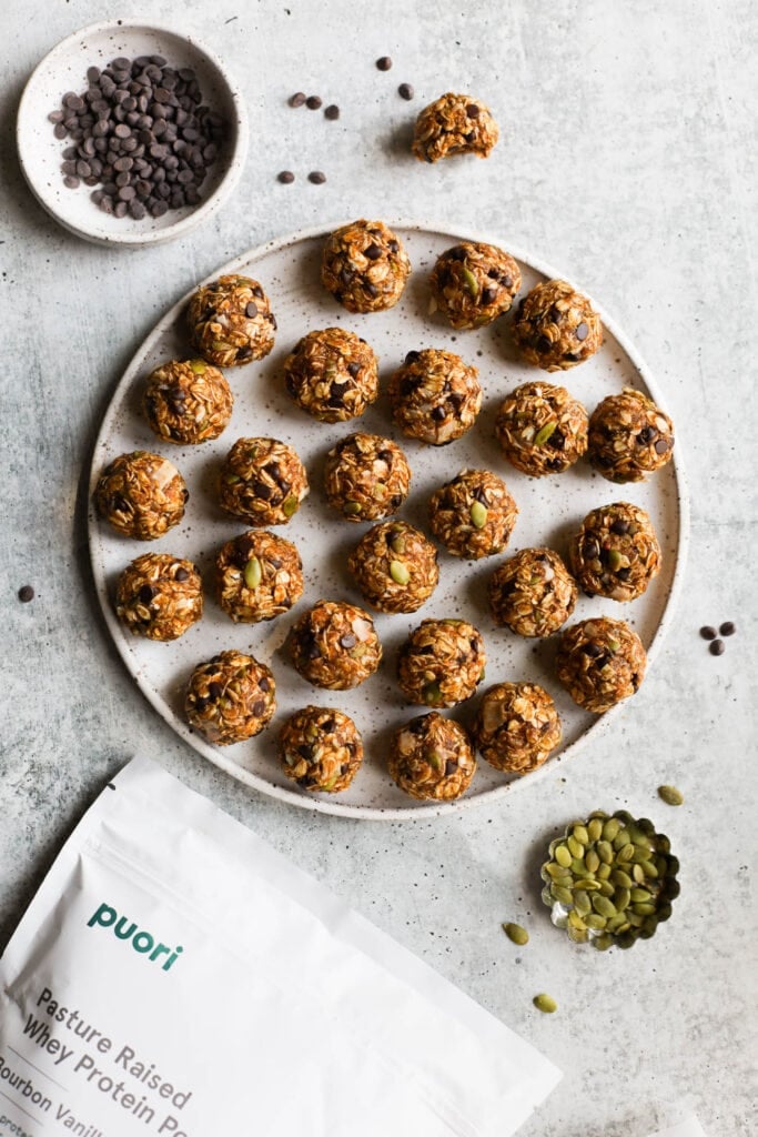 Overhead view round platter filled with pumpkin protein balls with mini chocolate chips and pepitas 