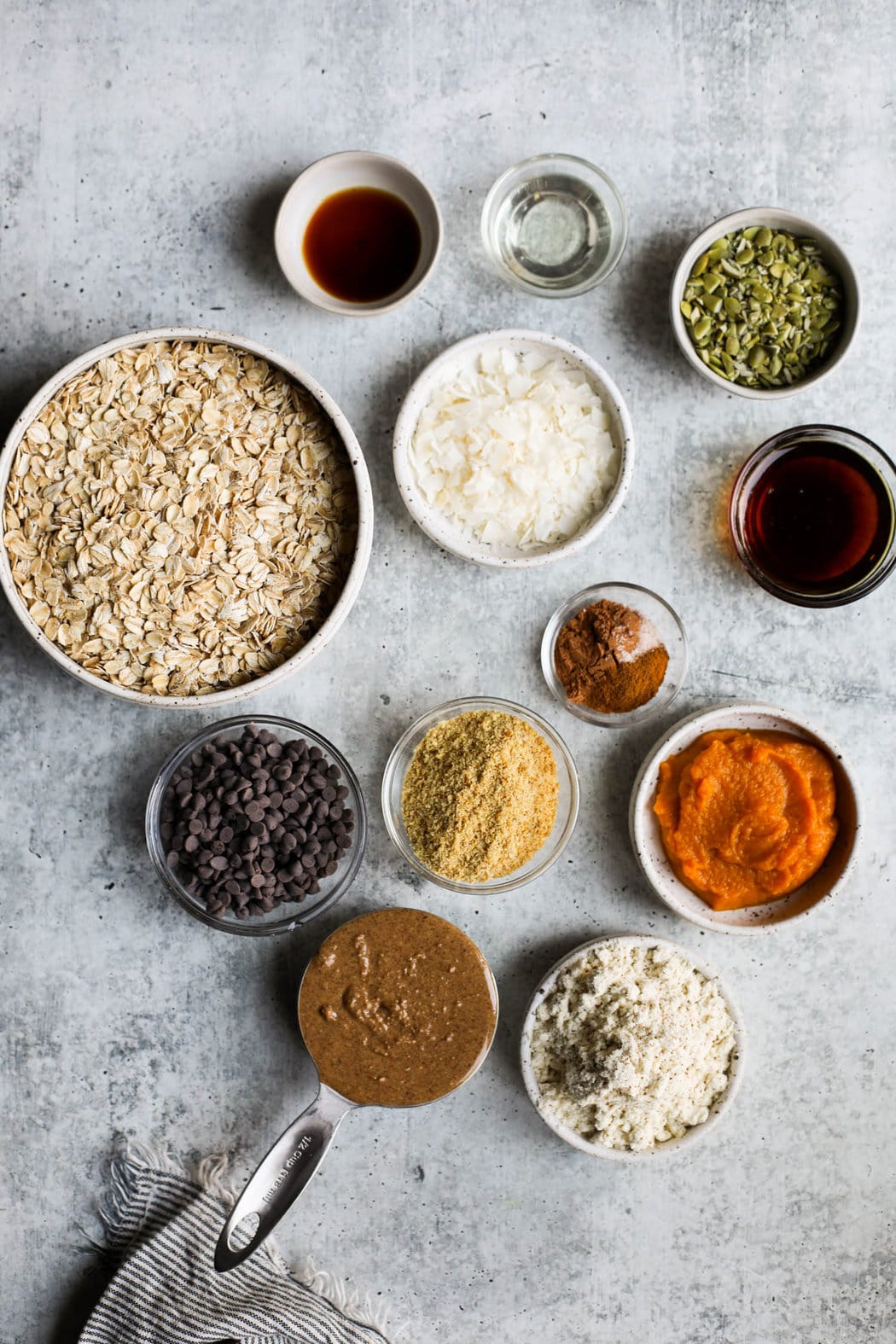 Overhead view all ingredients for pumpkin protein balls arranged in small bowls