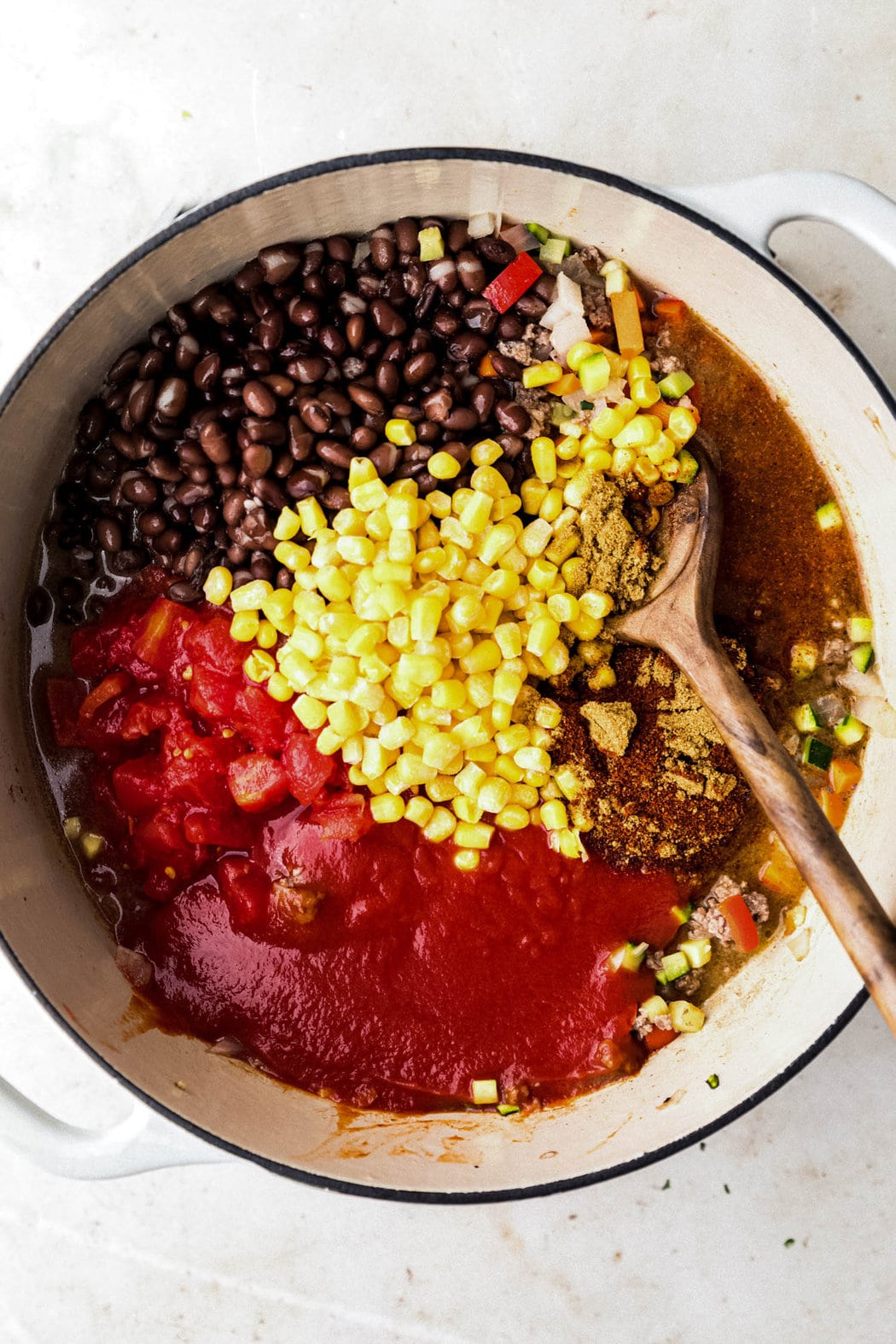 Overhead view pot filled with all ingredients for turkey chili ready to be stirred together