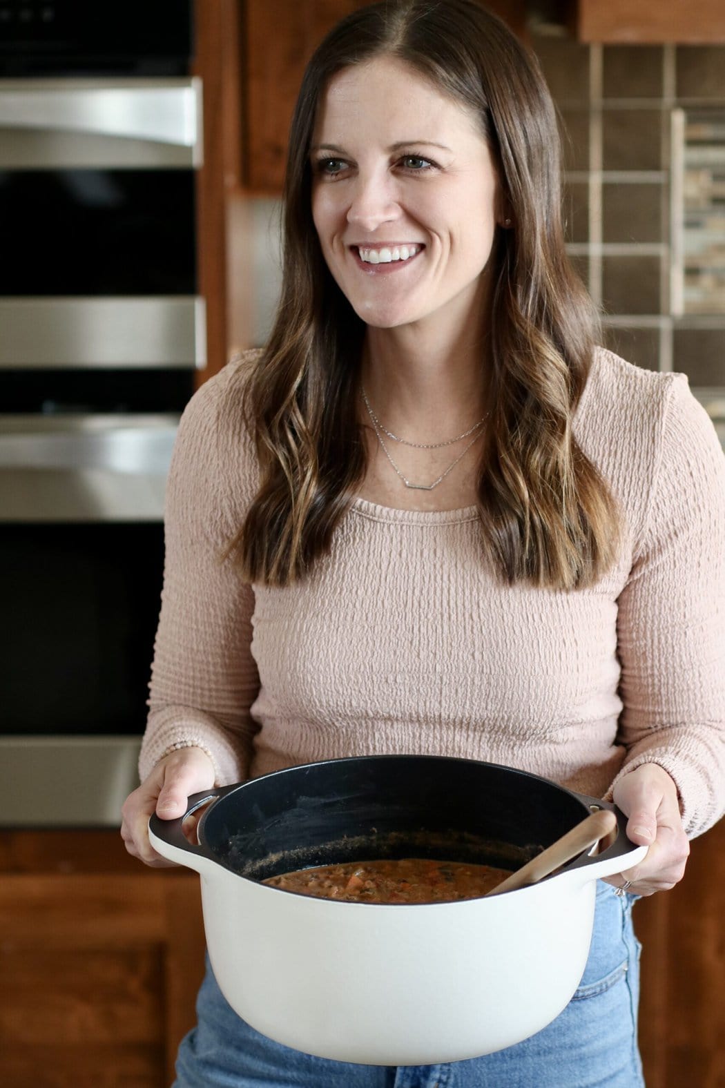 Woman in a kitchen making meal in a Caraway Dutch oven. 