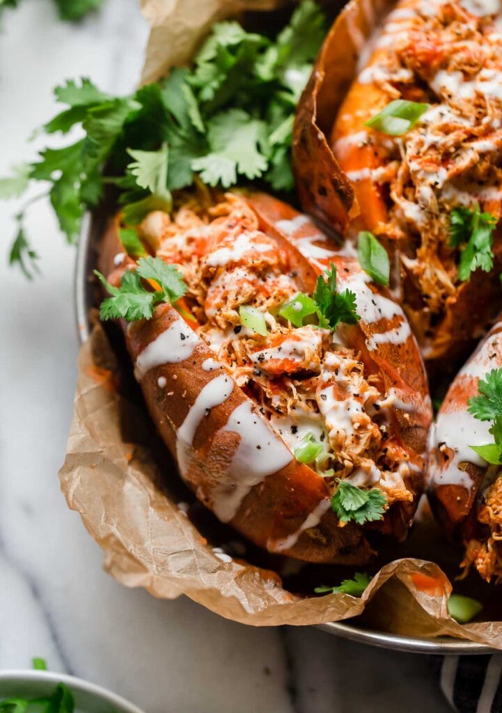 Overhead view stuffed baked sweet potato with buffalo chicken topped with ranch