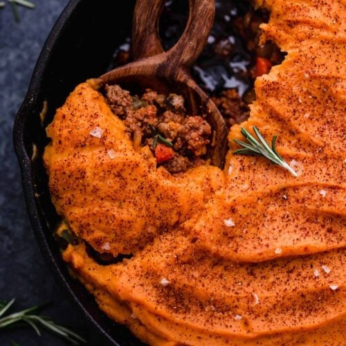 Overhead view cast iron skillet filled with shepherd's pie topped with mashed sweet potatoes