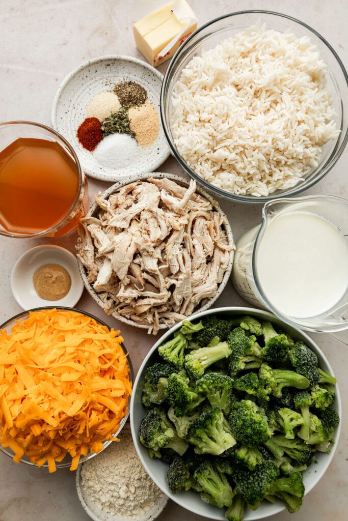 Overhead view all ingredients for cheesy chicken skillet arranged together in bowls