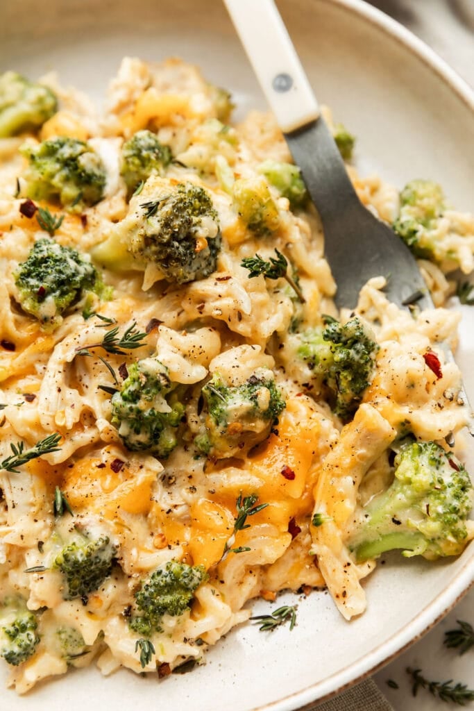 Close up view cheesy chicken and broccoli rice skillet meal on plate with fork
