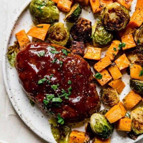 Plate filled with serving of sheet pan mini meatloaf with roasted vegetables