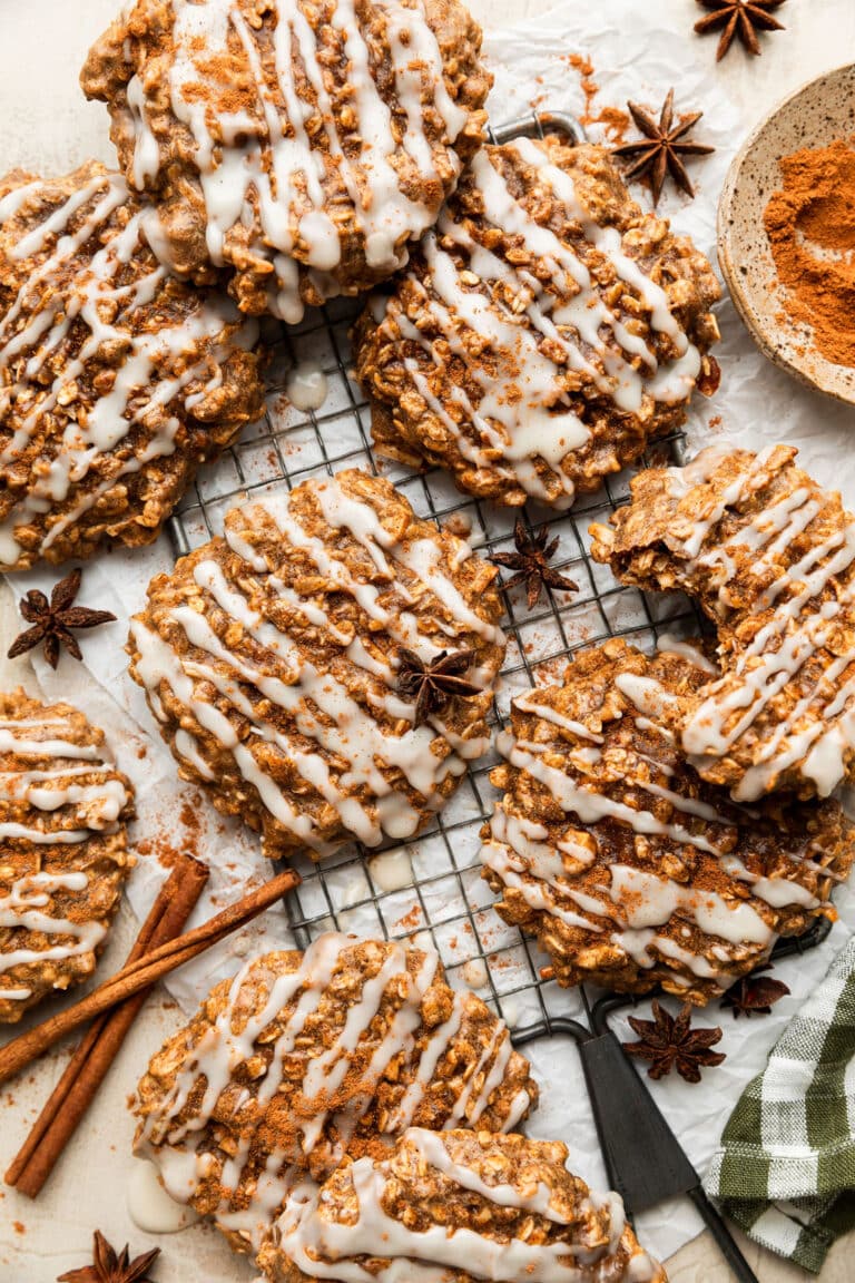 Chai spice protein breakfast cookies on a cooling rack drizzled with white icing and warm spices.