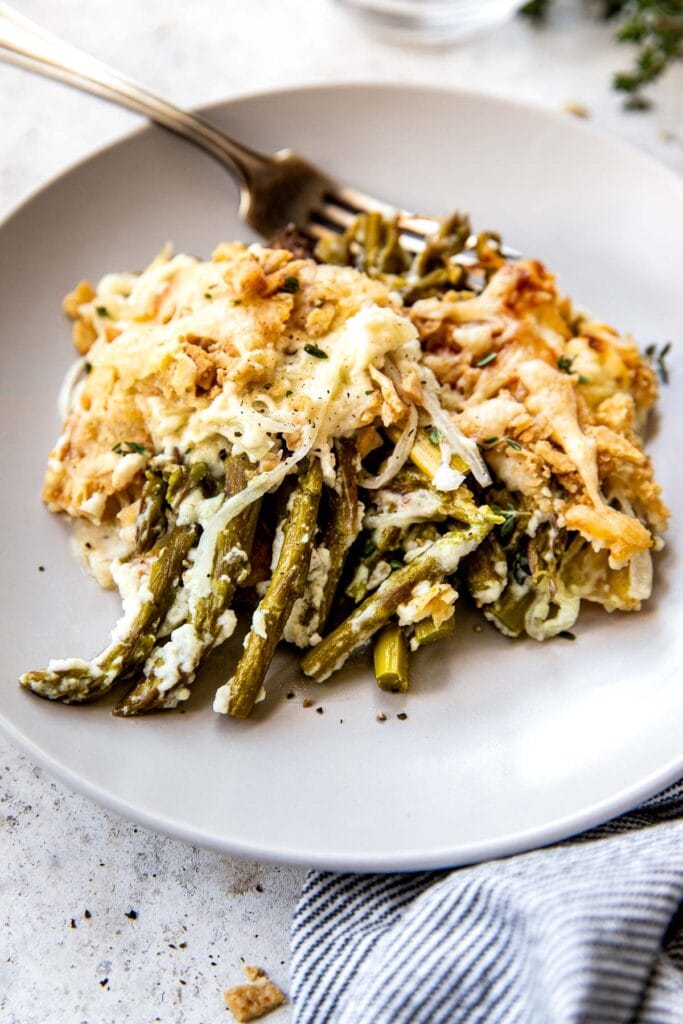 Asparagus casserole plated on a white plat with a fork.