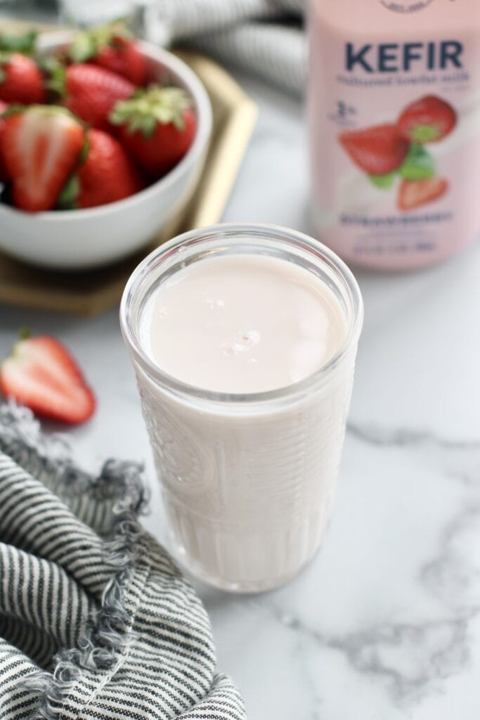 Close up view of a glass of strawberry kefir. 