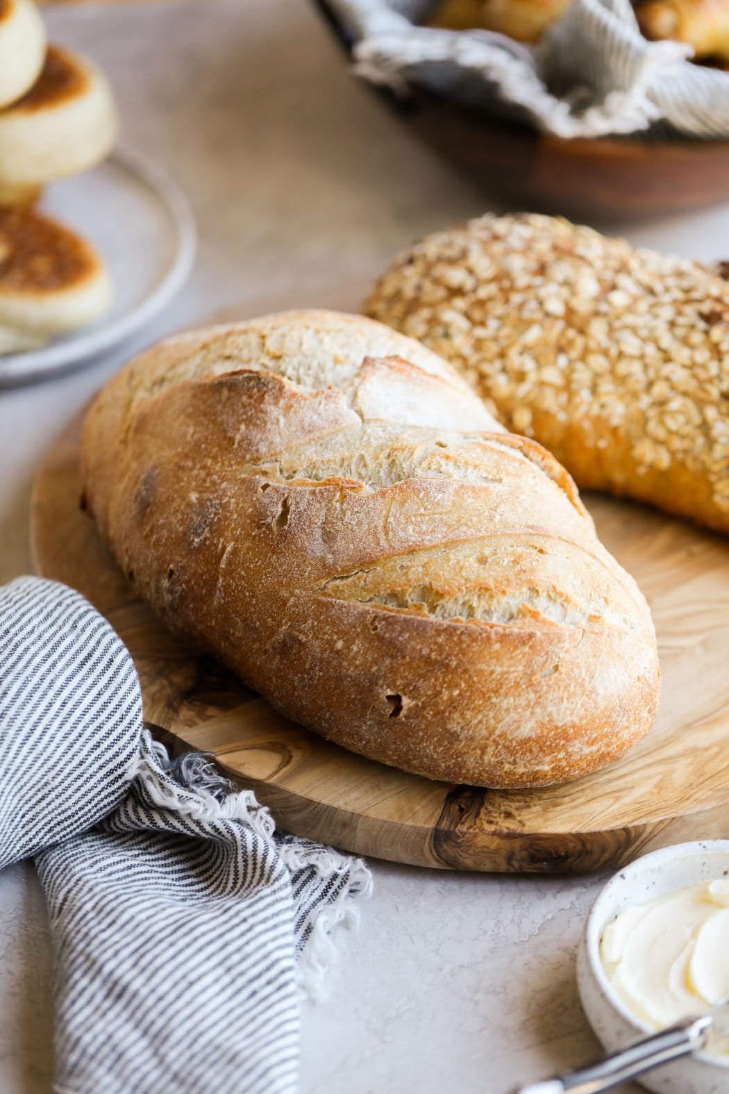 Close up view of sourdough bread loaves on wooden cutting board.