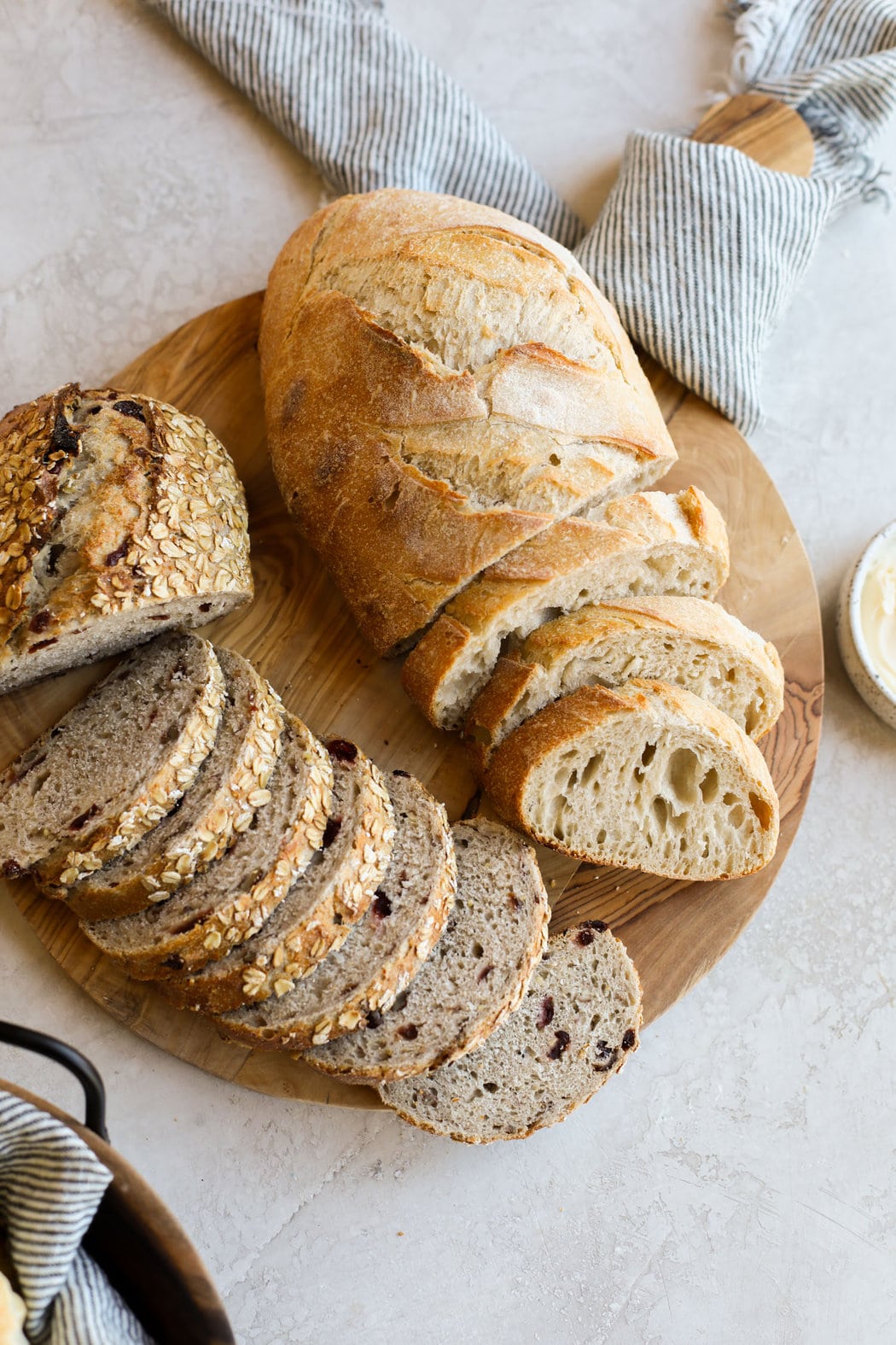 Close up view of sliced sourdough bread loaves on a wooden cutting board. 