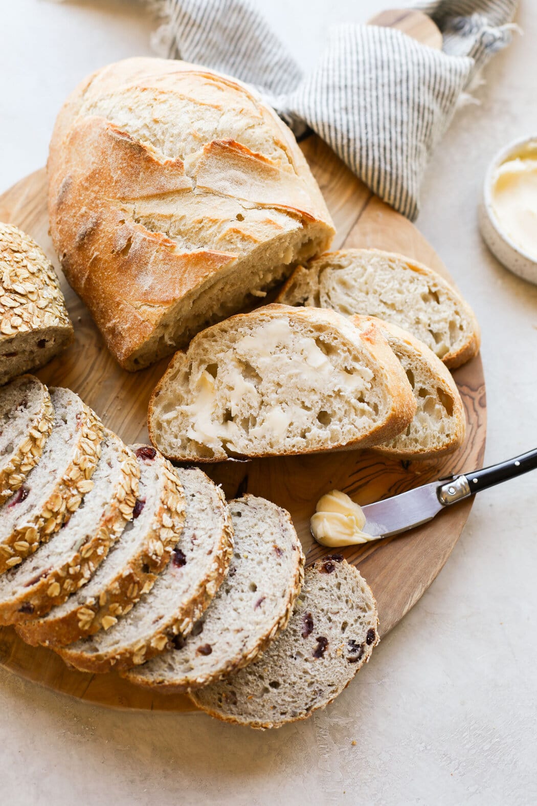 Close up view of sliced sourdough bread loaves topped with butter. 