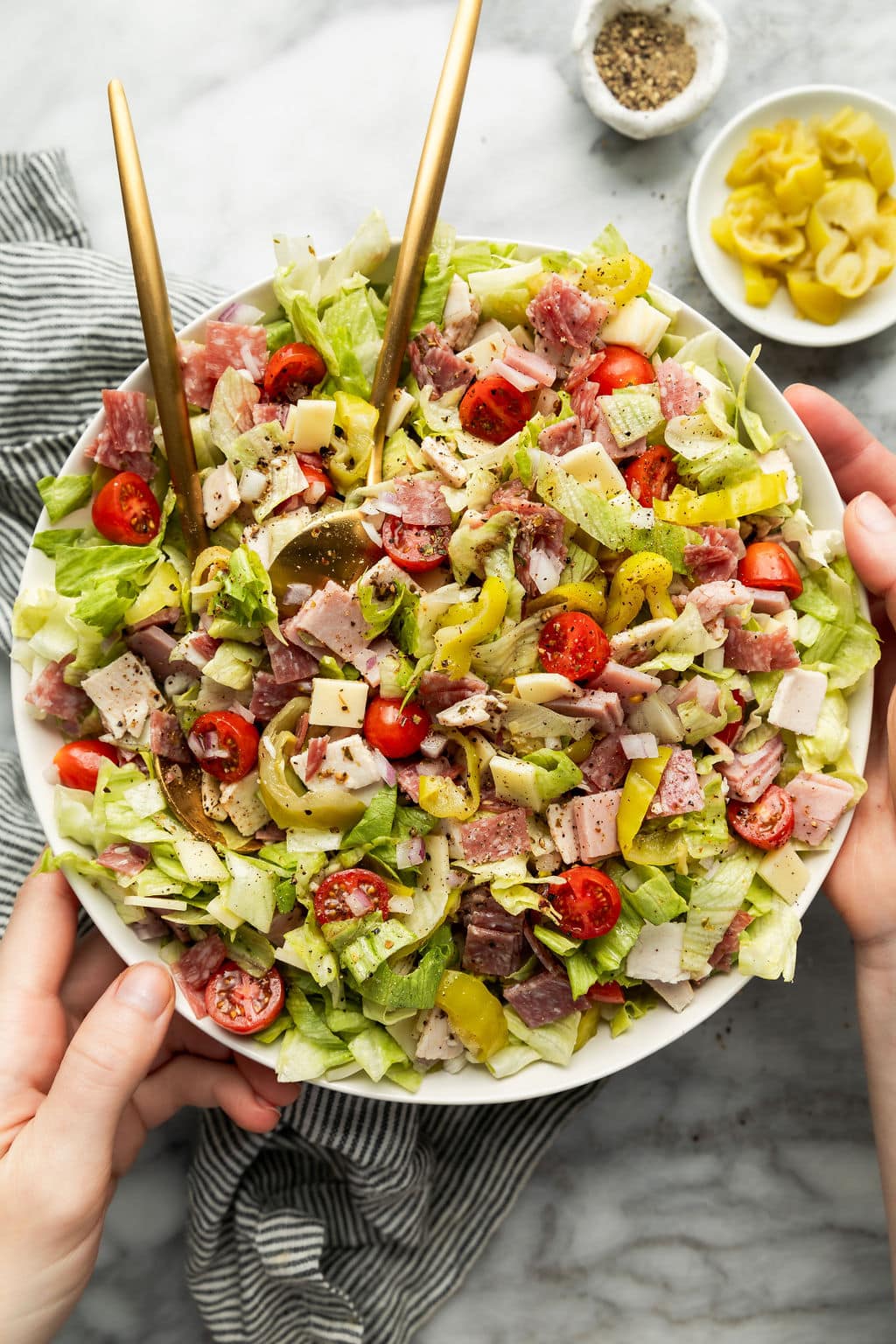 Overhead view of a large bowl of sub in a tub topped with fresh Italian dressing and oregano. 