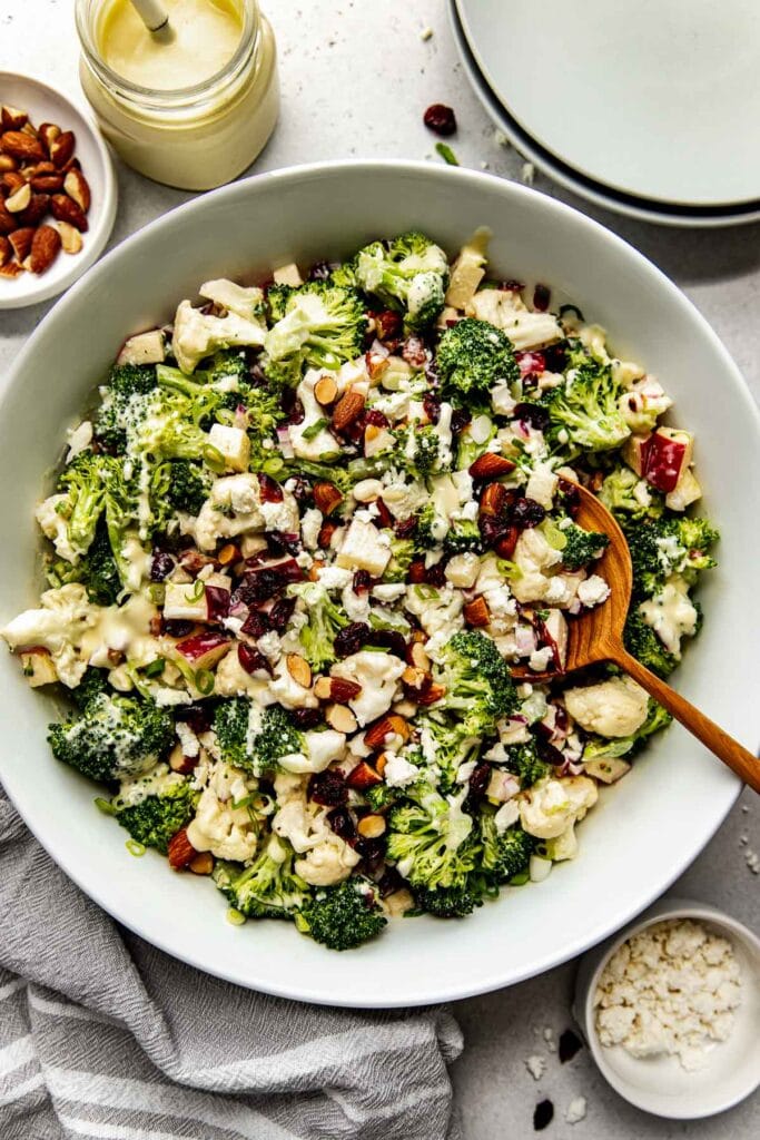 Overhead view apple broccoli salad with cranberries and cauliflower in a large serving bowl
