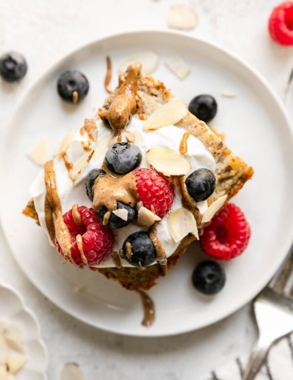 Overhead view serving of protein baked oatmeal topped with yogurt and fresh berries.