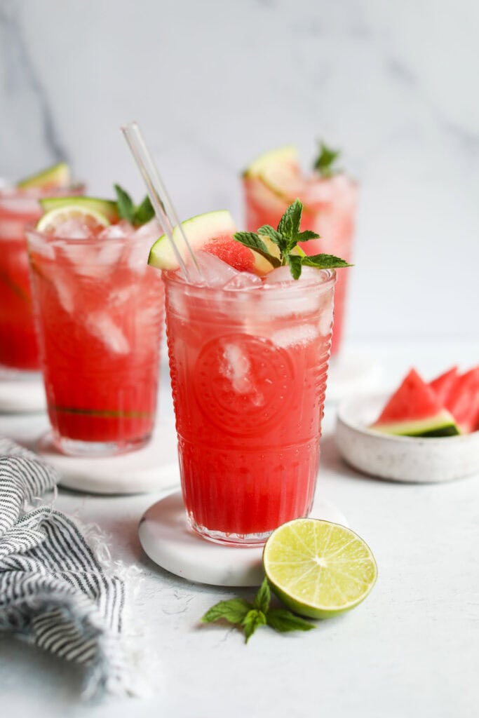 Side view tall glass cups filled with watermelon mocktail drink