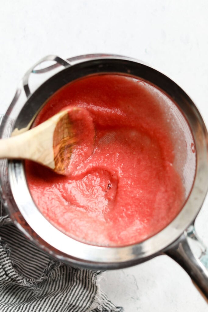 Blended watermelon poured through a strainer to remove watermelon pulp