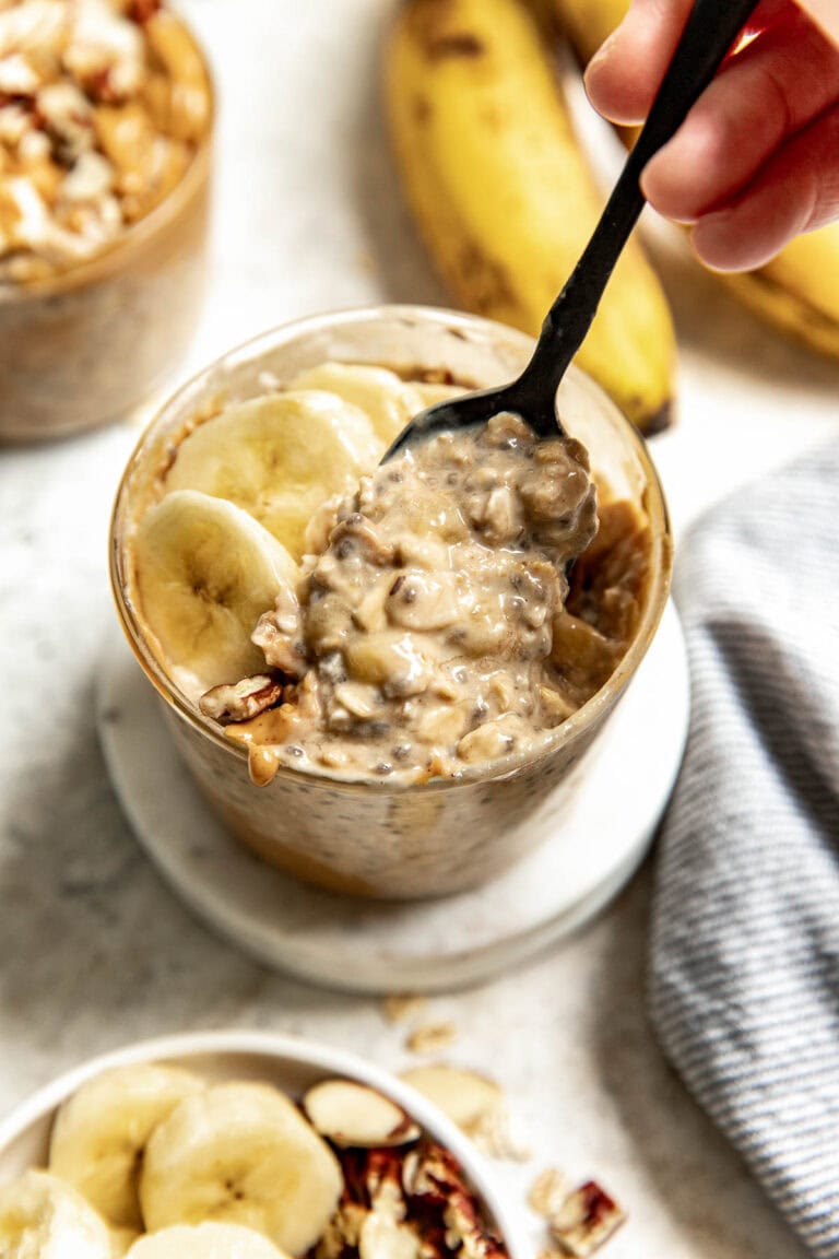 Close up view of a spoon scooping a bite of peanut butter banana overnight oats. 