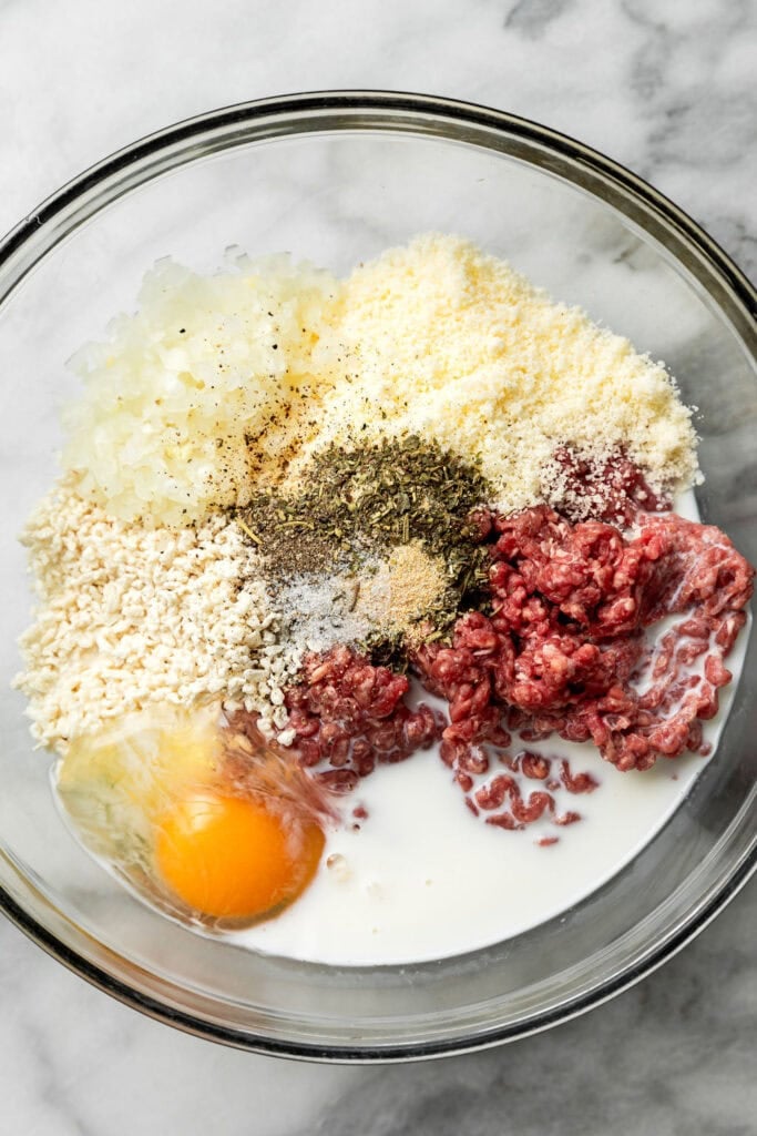 Overhead view of a bowl of ingredients for Baked Italian Meatballs, ready for combining. 