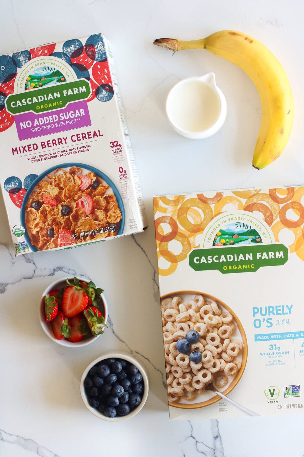 Overhead view of 2 boxes of cascadian farm organic cereals next to fresh fruit. 