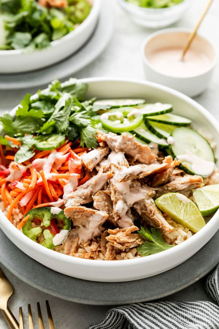 Close up view of a Banh Mi Rice bowl topped with a spicy mayo sauce. 