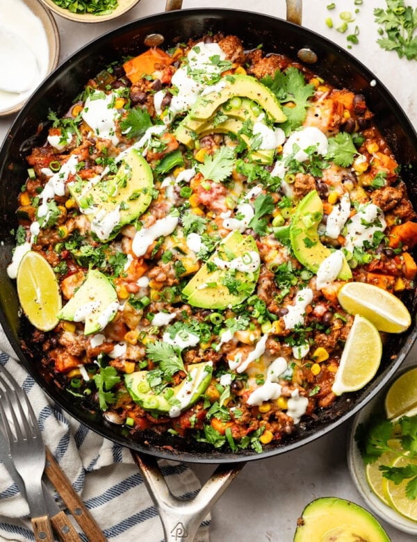 overhead view ground beef zucchini skillet in cast iron skillet topped with sour cream