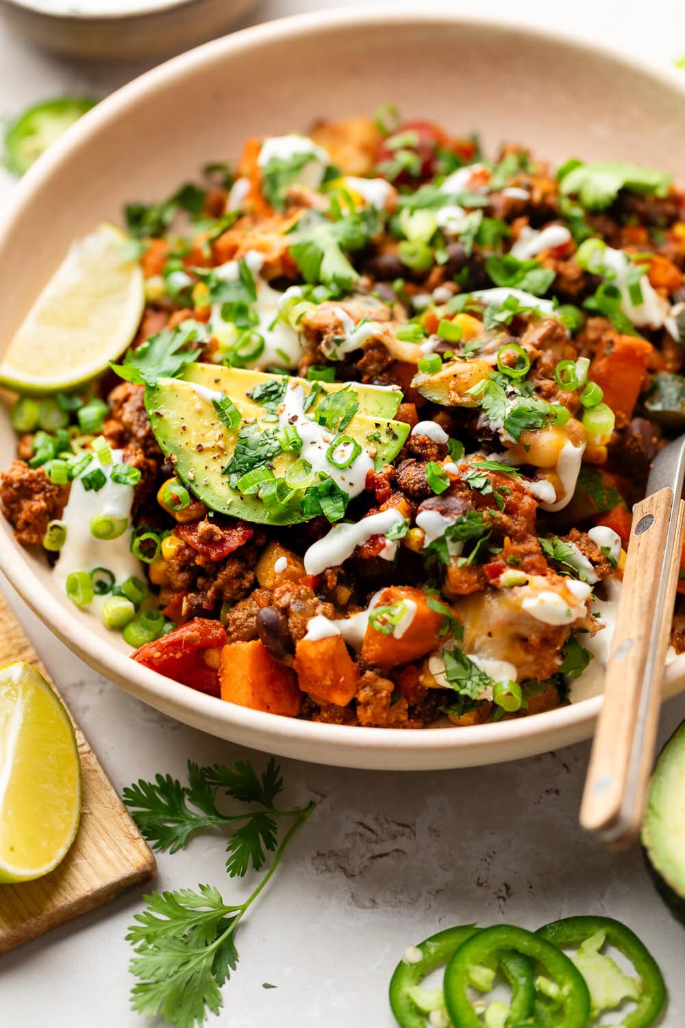 Close up view of a plate of Ground Beef and Zucchini Skillet topped with sliced avocado and fresh cilantro.