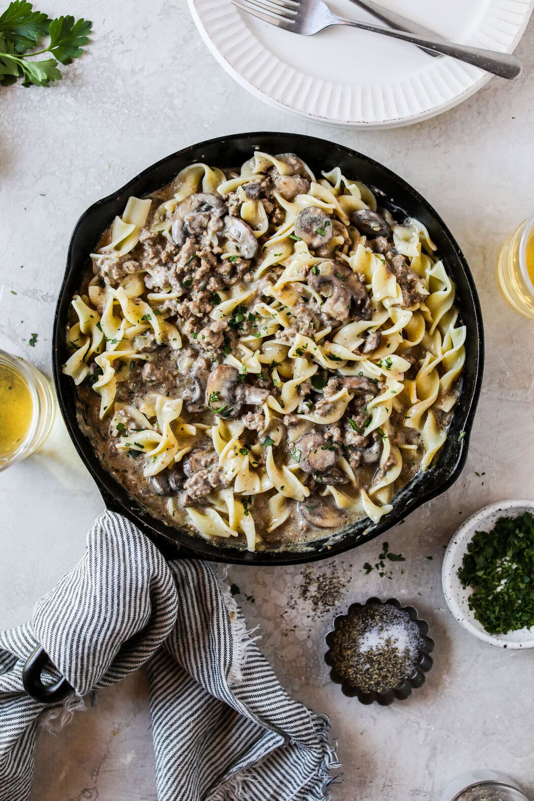 Overhead view of a pan filled with ground beef stroganoff topped with fresh herbs. 