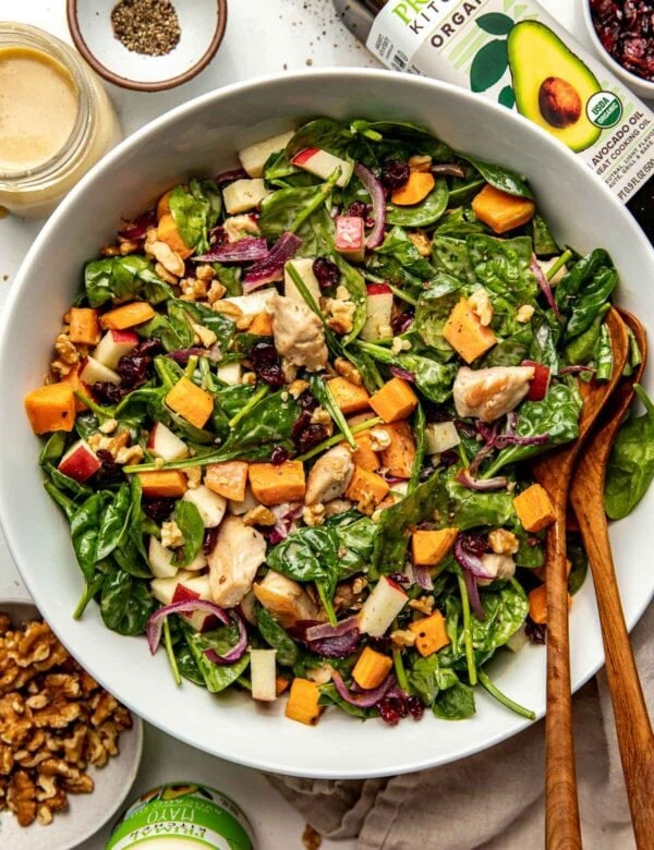 Overhead view harvest chicken salad in serving bowl topped with maple dijon dressing