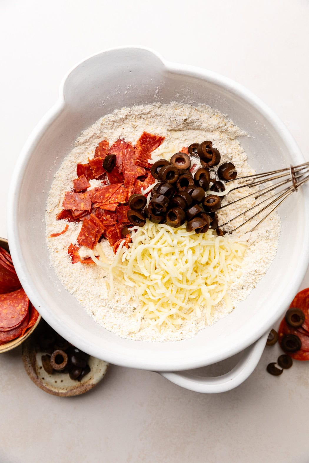 Overhead view of Pepperoni Pizza Muffins ingredients in a bowl ready for stirring. 