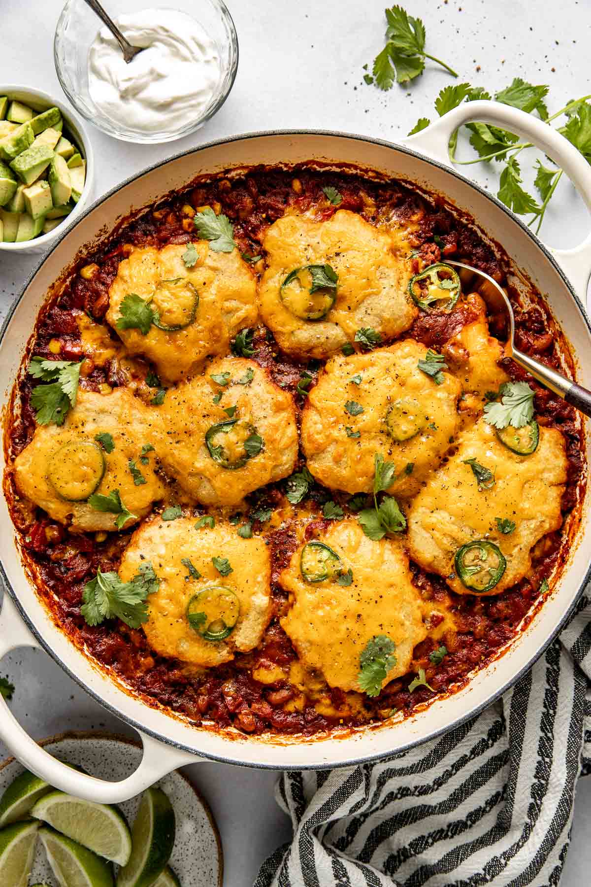 Overhead view of a pan filled with freshly baked Chili Cornbread Casserole topped with cilantro and jalapeno. 