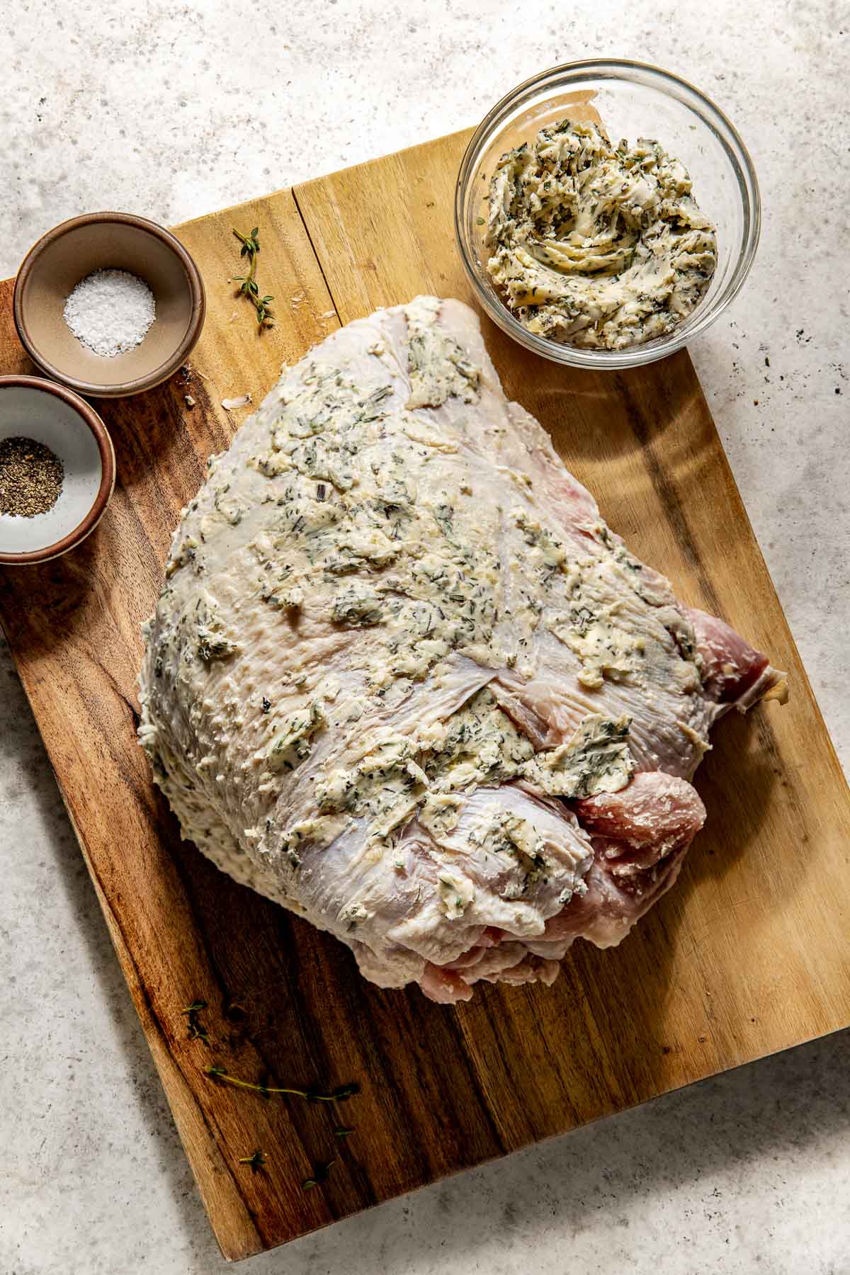 Bone in turkey breast smothered in butter and fresh herbs ready for roasting. 