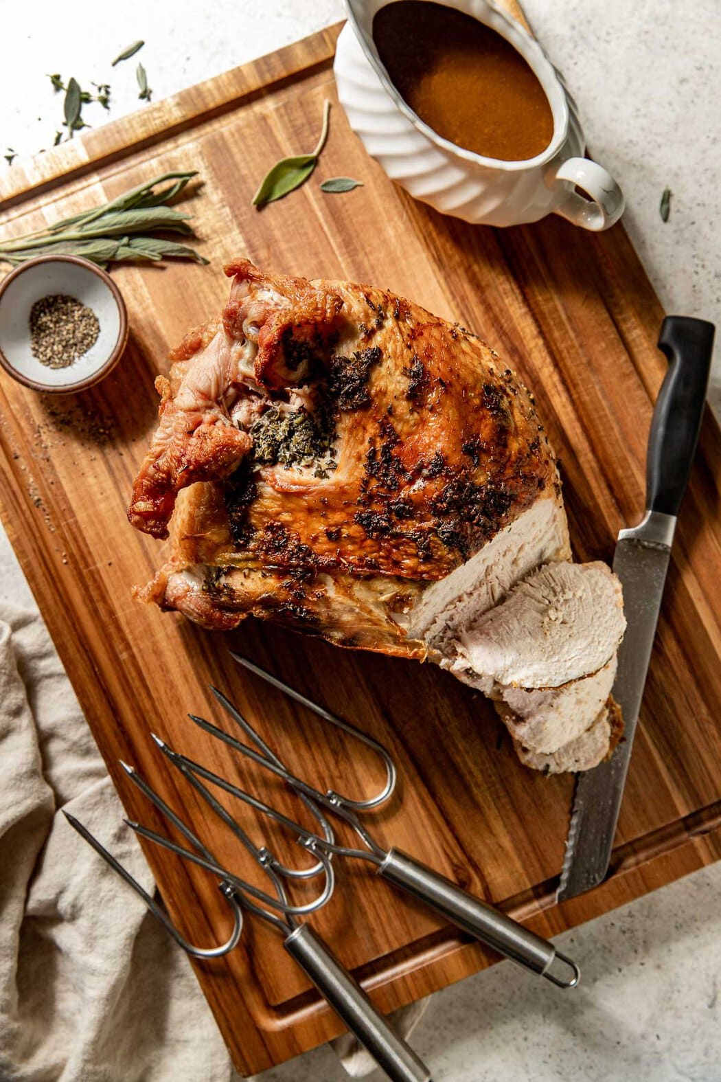 Freshly roasted bone in turkey breast on a cutting board ready for slicing and serving. 