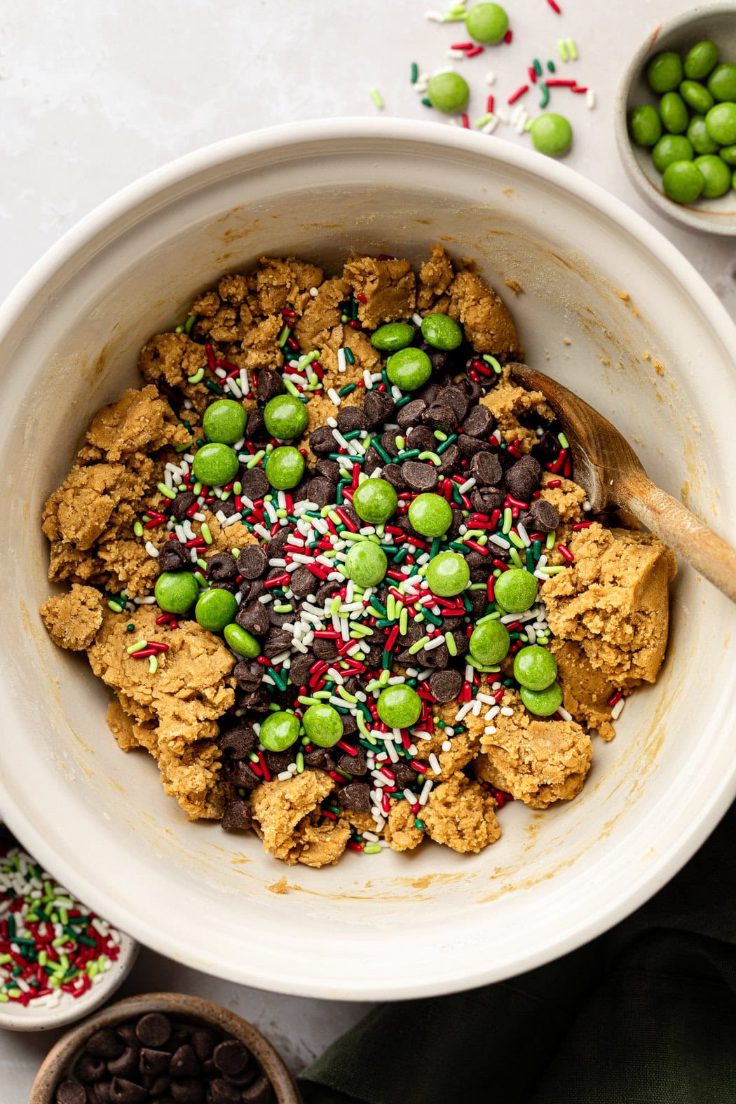 Overhead view of a bowl of Ana’s Christmas Cookies dough topped with sprinkles and candy chocolate pieces. 